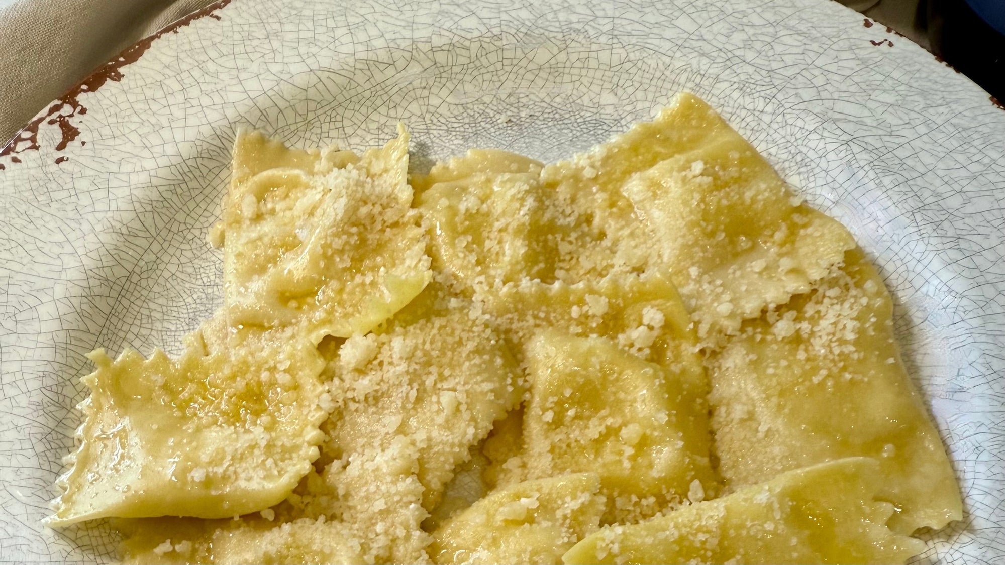 Plate of potato tortelli topped with Parmigiano Reggiano