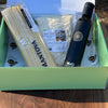 Box containing Mantova pasta, a bottle of oil, and other items on a wooden surface.